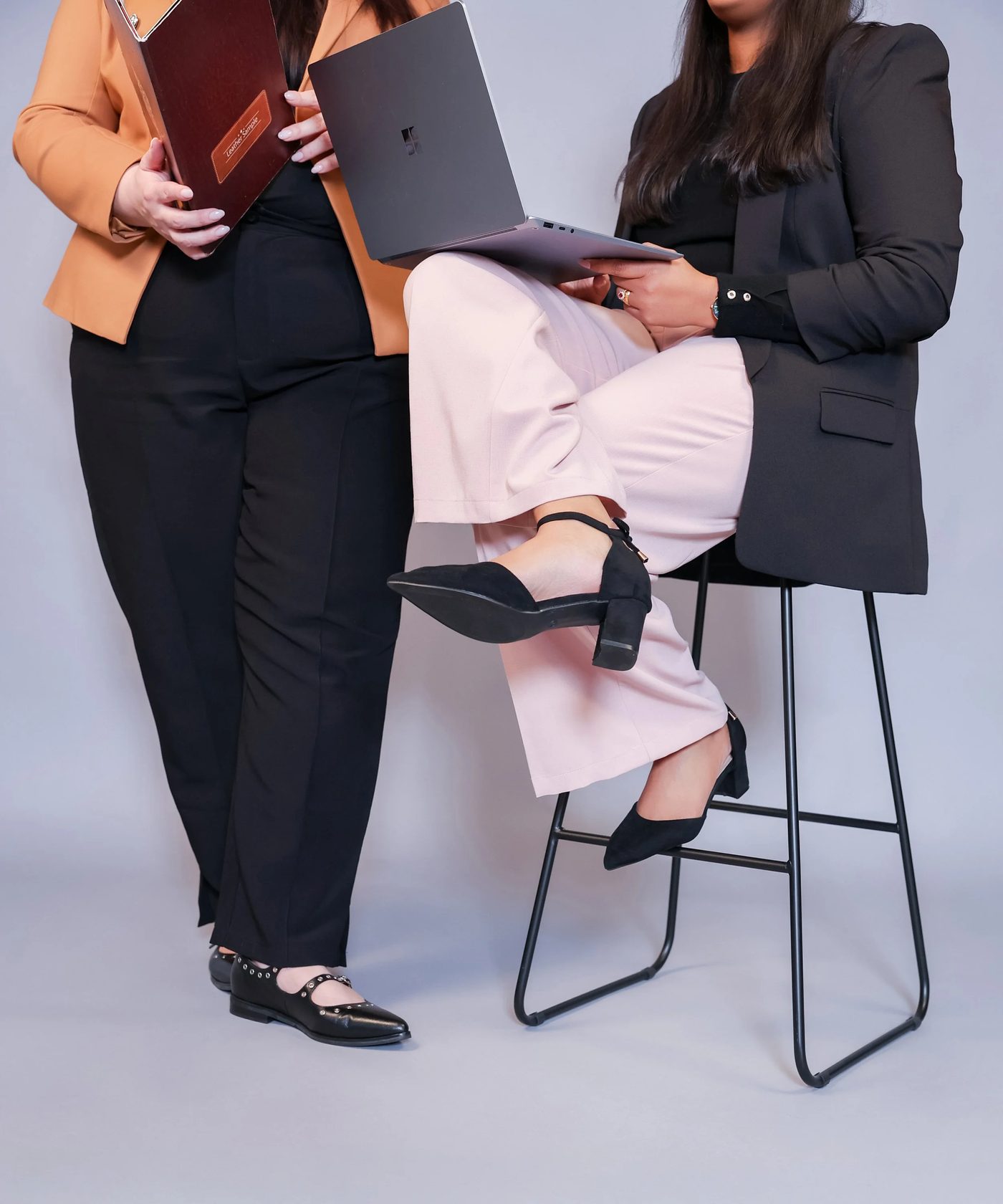 Two professionals with a laptop and notebook